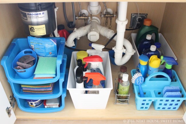 cleaning supplies organized under the kitchen sink